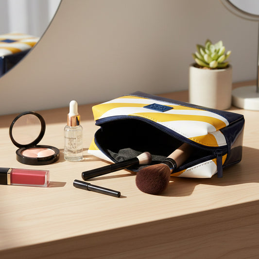 Neceser pequeño rayas amarillas y charol azul marino en uso dentro de bolso