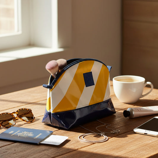 Neceser pequeño rayas amarillas y charol azul marino en uso para maquillaje
